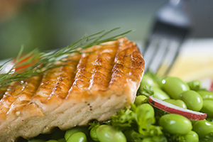 Salmão grelhado com ervas sobre uma cama de edamame.
