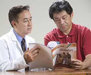 糖尿病ワークブックを見る男性と医師。